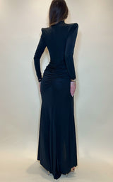 Woman wearing a black evening gown with a fitted bodice and flowing skirt against a white background