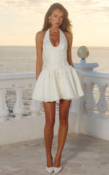 Woman in a white dress standing on a balcony with a scenic background