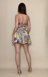 Woman wearing a colorful strapless dress against a beige background