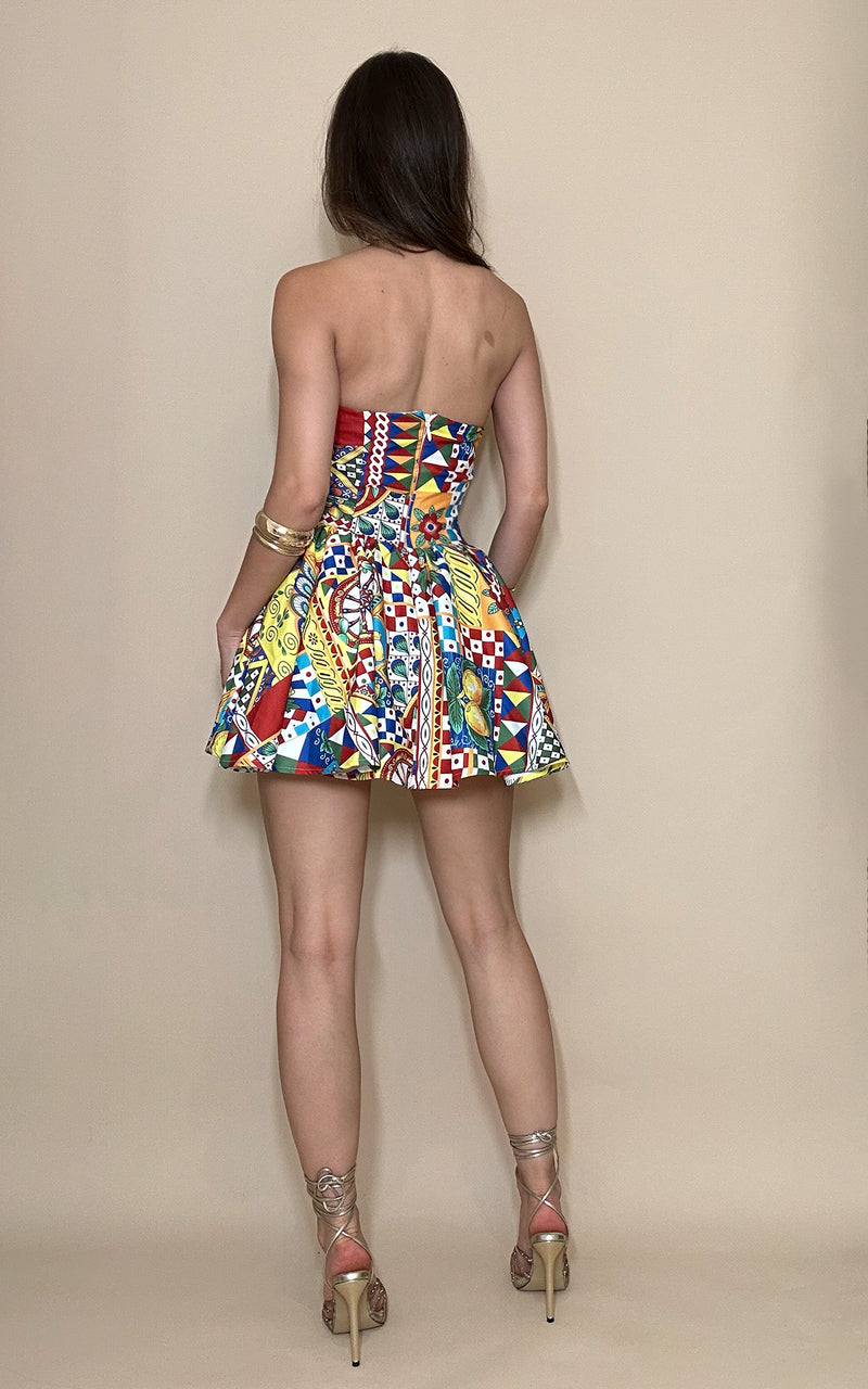 Woman wearing a colorful strapless dress against a beige background